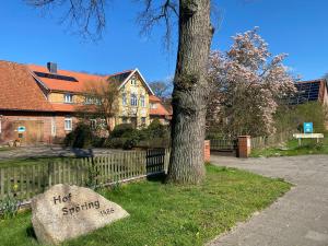 a rock sitting in the grass next to a tree at Roseneck am Neulandhof Spöring in Walsrode