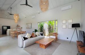 a living room with a couch and a table at Echo Beach Villa and Apartment in Canggu