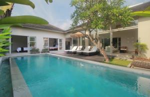 a swimming pool in the backyard of a villa at Echo Beach Villa and Apartment in Canggu