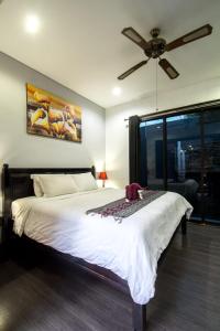 a bedroom with a large bed with a ceiling fan at Villa cinta buana 1 in Legian +16 photos