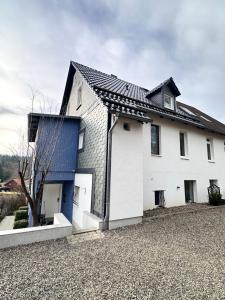 una casa blanca con techo negro en Fachwerkhaus von 1894, Hahnenklee-Bockswiese Getaway, en Hahnenklee-Bockswiese