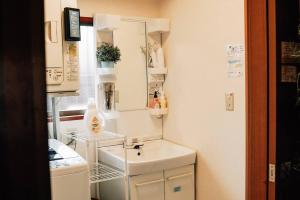 una pequeña cocina con lavabo y espejo en Tipy records inn, en Odawara