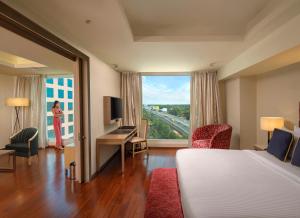 a hotel room with a bed and a large window at O by Tamara, Trivandrum in Trivandrum