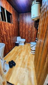 a bathroom with two toilets and a wooden floor at Nigeen Residency Resort , Srinagar in Srinagar