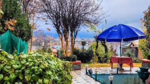 斯利那加的住宿－Nigeen Residency Resort , Srinagar，花园里的蓝伞,带桌子