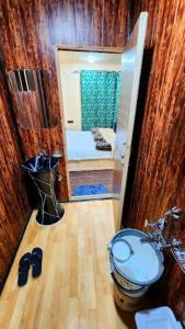 a bathroom with a toilet and a door to a bedroom at Nigeen Residency Resort , Srinagar in Srinagar