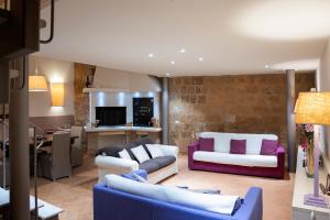 a living room with two couches and a kitchen at Casa Vèra Affittacamere Appartamenti in Orvieto