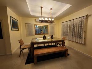 a dining room with a table and chairs and a chandelier at KT Villa 963 in Bangkok