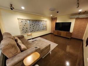 Il comprend un salon doté d'un canapé et d'une télévision à écran plat. dans l'établissement KT Villa 963, à Bangkok