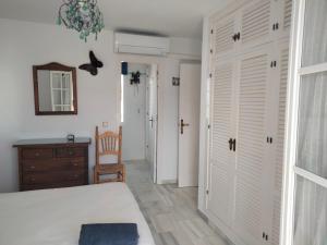 Schlafzimmer mit einem Bett, einer Kommode und einem Spiegel in der Unterkunft Apartamento primera línea de playa in Manilva