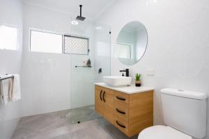 a white bathroom with a sink and a mirror at Bamboo Villa - Pet friendly luxury Villa next to Botanical Gardens in Edge Hill