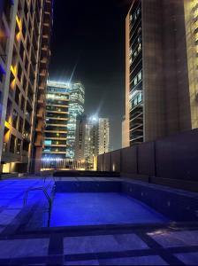 a swimming pool in the middle of a city at night at Shared Private Room in Downtown Business Bay in Dubai