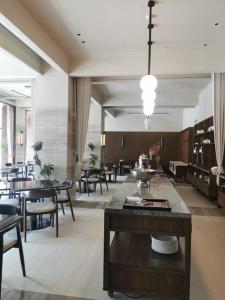 a dining room with tables and chairs and a large room at Guus Hotel in Zengcheng