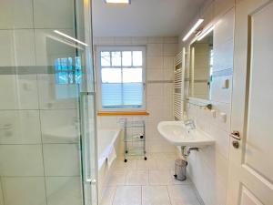 a white bathroom with a sink and a shower at Neue Villa Ernst - Ferienwohnung 4 in Bansin +18 photos