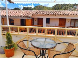 a patio with a table and chairs on a balcony at Paqarina San Blas in Cusco