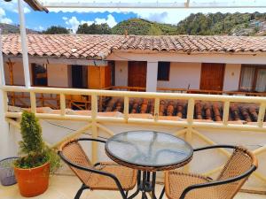 a patio with a table and chairs on a balcony at Hostal Paqarina San Blas in Cusco