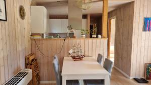comedor con mesa blanca y sillas en Charming summer house close to the sea, en Dronningmølle