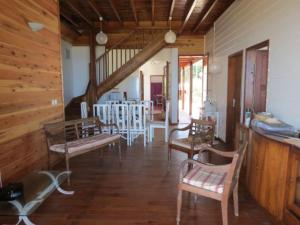 Una sala de estar con sillas y un comedor. en Villa Joséphine sur la plage, en Saint-Paul