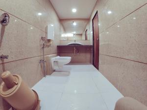 a bathroom with a toilet and a sink at Hotel Nawanagar Residency in Jamnagar