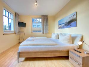 ein Schlafzimmer mit einem großen Bett und einem Schreibtisch in der Unterkunft Neue Villa Ernst - Ferienwohnung 4 in Bansin