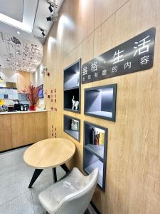 a table and chairs in a restaurant with writing on the wall at Shanghai Ange Hotel - Next to Longyang Road Subway Station, Near New Internatonal Expo Center in Shanghai