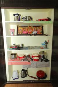 a shelf filled with pots and pans in a kitchen at Vellore Service Apartments Unit 1 in Vellore