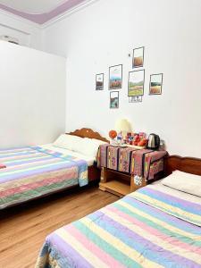 a bedroom with two beds and a table in it at Huong Thao Hostel & Tours in Dien Bien Phu