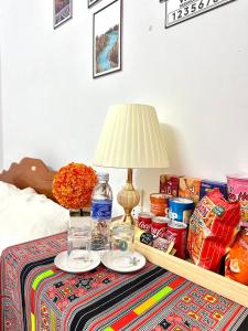 a table with a lamp and some food and drinks at Huong Thao Hostel & Tours in Dien Bien Phu