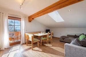 a living room with a table and a couch at Gugg Hof - Familie Hölzl in Hopfgarten im Brixental