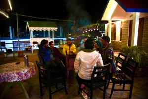 a group of people sitting outside a restaurant at night at Backpackers Den (TRC) in Gangtok
