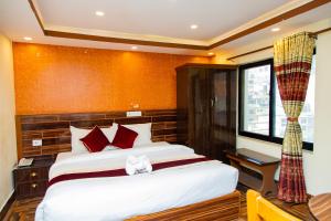 a bedroom with a large bed and a window at Hotel Everest Regency in Kathmandu