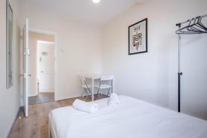 a white room with two beds and a table at APlaceToStay Central London Apartment, Zone 1 OX in London