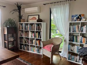 a room with two book shelves filled with books at The Cowrie Shell, Hydeaway Bay in Hideaway Bay