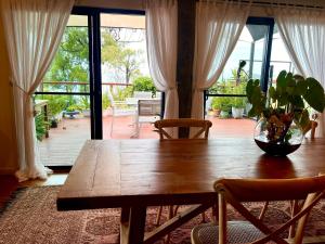 a dining room table with a vase on top of it at The Cowrie Shell, Hydeaway Bay in Hideaway Bay