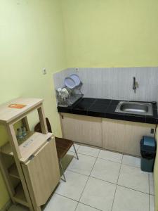 uma pequena cozinha com um lavatório e um balcão em PROMOSIA GUEST HOUSE em Surabaya