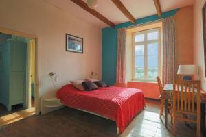 - une chambre avec un lit doté d'une couverture rouge et d'une fenêtre dans l'établissement Gite 1, à Bégard