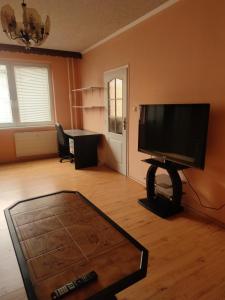 een woonkamer met een flatscreen-tv en een tafel bij Apartment in the Levice in Levice