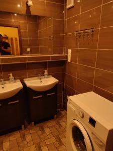 een badkamer met 2 wastafels en een wasmachine bij Apartment in the Levice in Levice