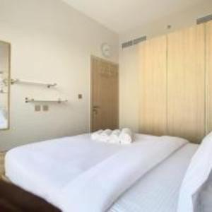 1 dormitorio con 1 cama blanca grande en una habitación en Key View - Navitas Tower A, en ‘Ūd al Bayḑāʼ