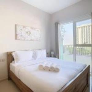 1 dormitorio blanco con 1 cama con 2 toallas en Key View - Navitas Tower A, en ‘Ūd al Bayḑāʼ