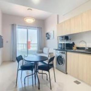 a kitchen with a table and chairs in a room at Key View - Navitas Tower A in ‘Ūd al Bayḑāʼ