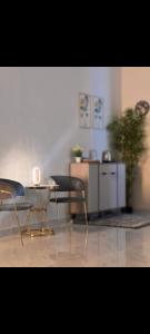 una mesa y sillas en una habitación con una planta en استراحة قصَّة en Barka