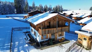 una casa con nieve en el techo en Feriendorf Via Claudia Haus 75 Waldromantik, en Lechbruck