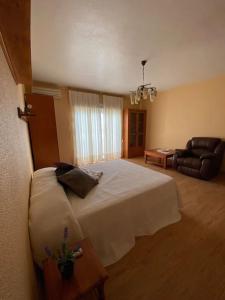 Un dormitorio con una gran cama blanca y un sofá. en Casa Pepe, en Níjar