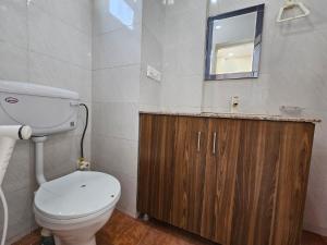 a bathroom with a toilet and a sink and a mirror at Hotel Vistacrest Noida Sector 104 in Noida