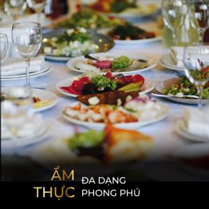 una tavola con piatti di cibo e bicchieri di vino di TTC Imperial Hotel a Hue