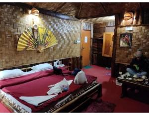 Hilltop Rabong Resort, Sikkim في Ravangla: غرفة نوم مع سرير كبير مع مروحة على الحائط