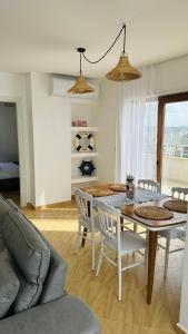 uma sala de estar com uma mesa de jantar e cadeiras em CURRILA STAYS em Durrës