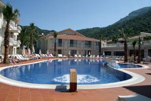 a large swimming pool with lounge chairs in a resort at Oludeniz Blue Lagoon Beach Hotel in Fethiye