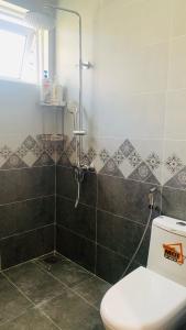 een badkamer met een douche en een toilet. bij Kat House Novaworld Phan Thiết in Bình Tú +14 foto's